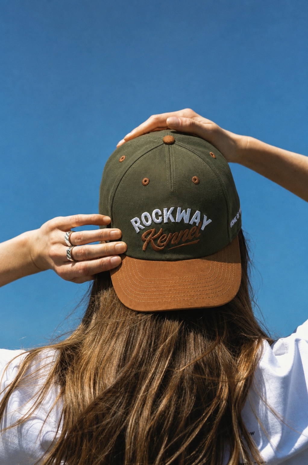 Rockway Kennel cap held against a clear blue sky