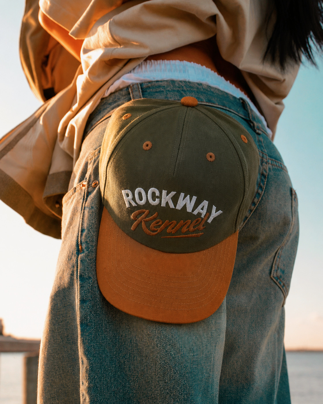 Two-tone Rockway Kennel cap held against denim